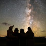 A family of four gazing at the Milky Way