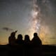 A family of four gazing at the Milky Way